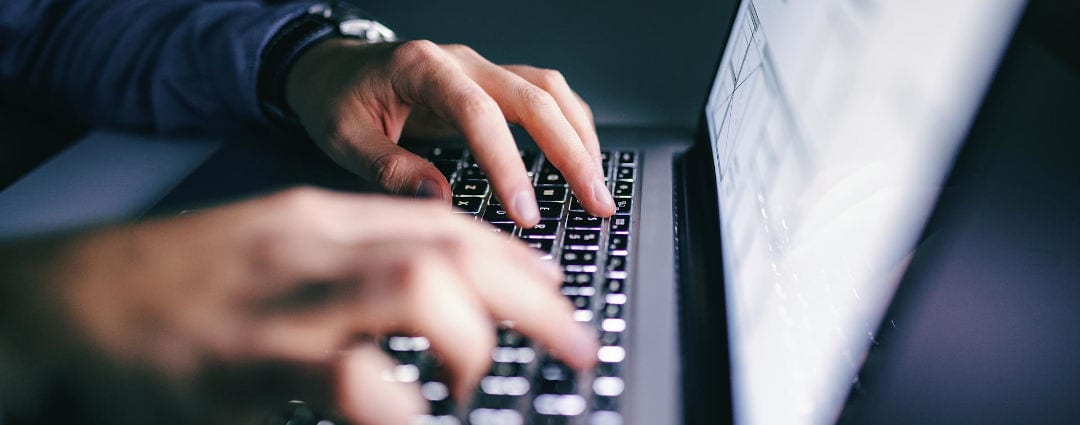 Close up of hands tying on a laptop. Night work concept.