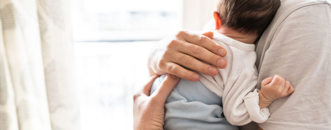 Affectionate love between a father and his newborn baby, father holding his son in his arms