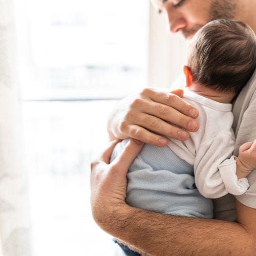 Affectionate love between a father and his newborn baby, father holding his son in his arms